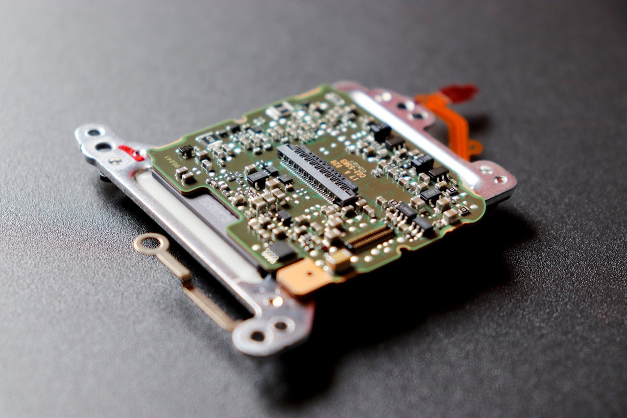 Detailed view of a microchip, showcasing intricate electronic components on a dark textured surface.